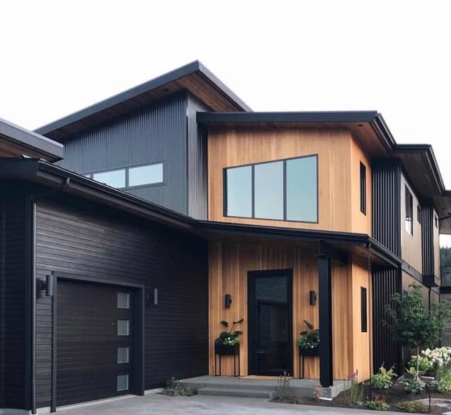 A black house with wooden sidling and glass windows 