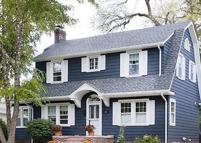 Blue house with white trim and black roof and white front door