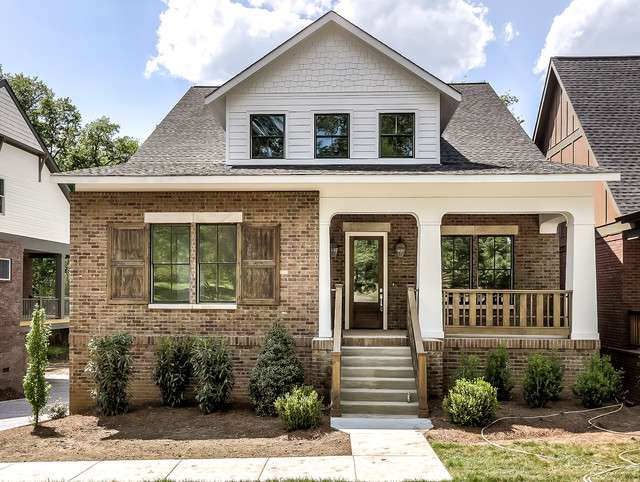 A white house with brick base and white trim windows