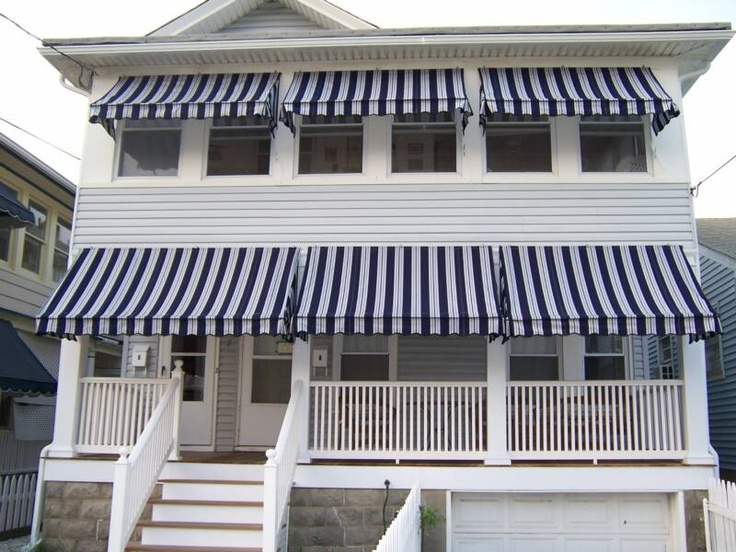 White house with blue awnings and white balcony