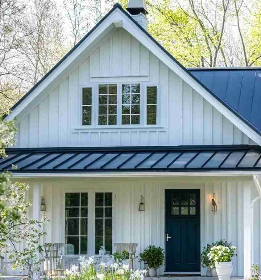 White house exterior with blue rooflines. and blue door and white trim windows