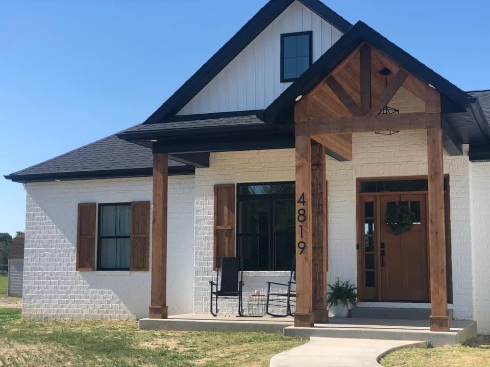 White house with black trim and wood shutters and door