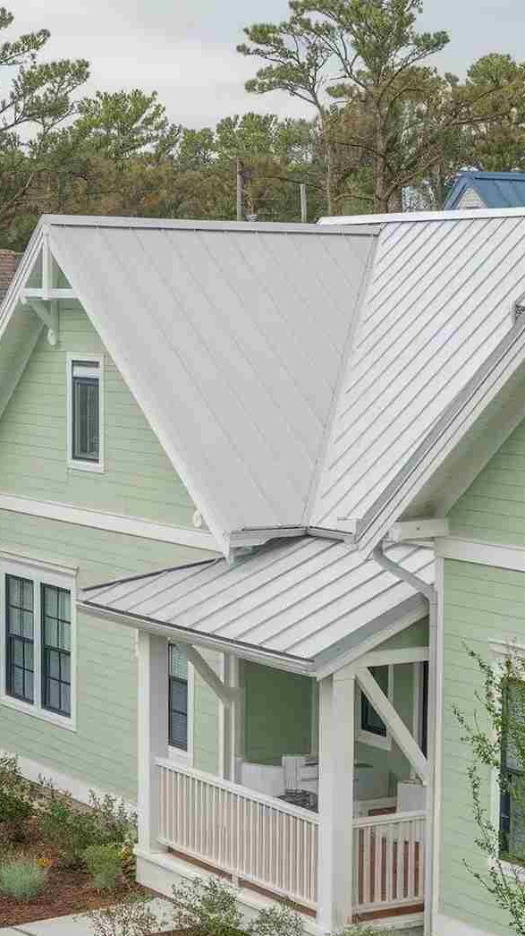 White roof on green house with white balcony