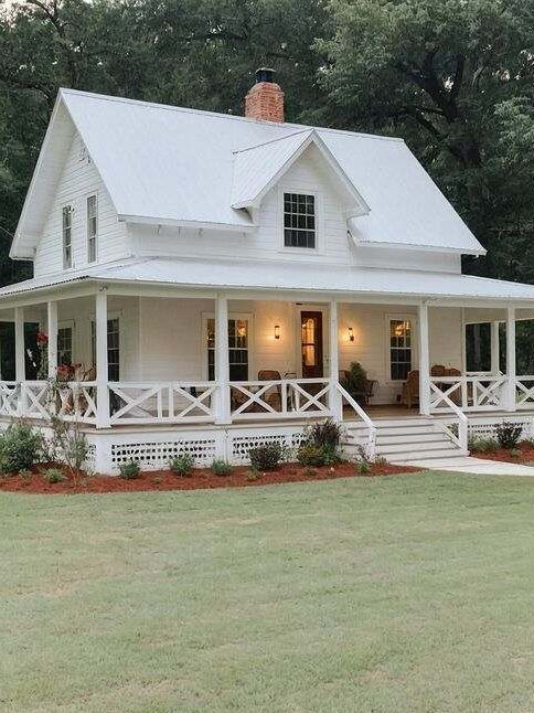 White house with fencing around house and lights on the wall and white railing