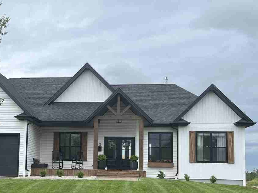 White house with black trim and gable roof and wood shutter and black trim windows