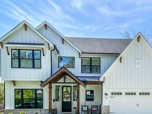 Wooden corbels on white house with black trim glass windows