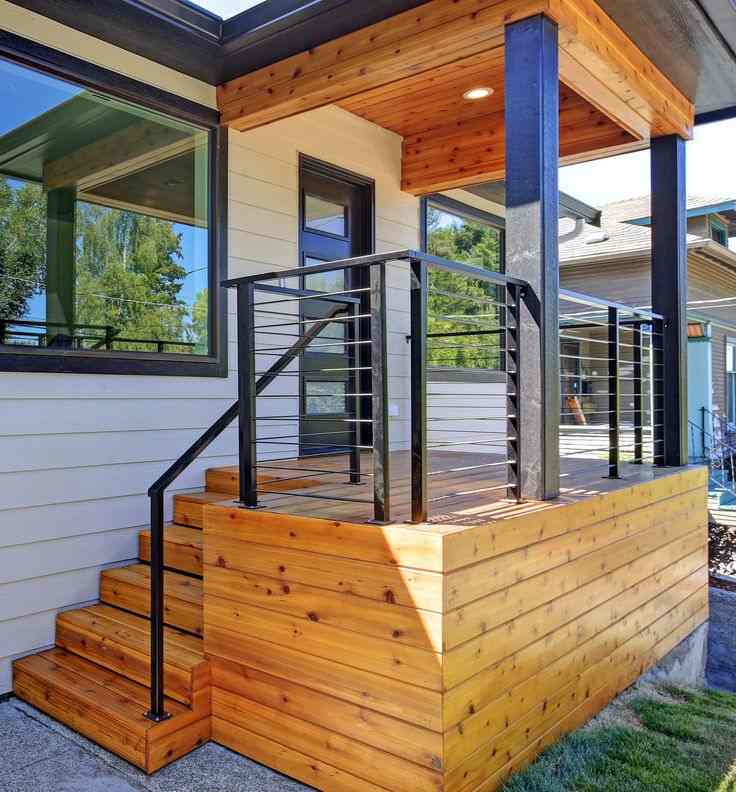 A white house with wooden deck and black railing
