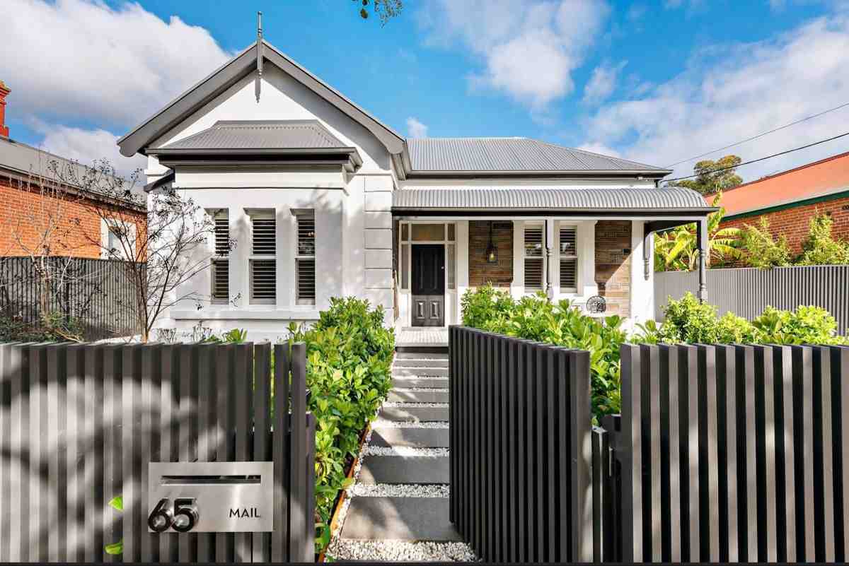 Wooden fencing around white and black house