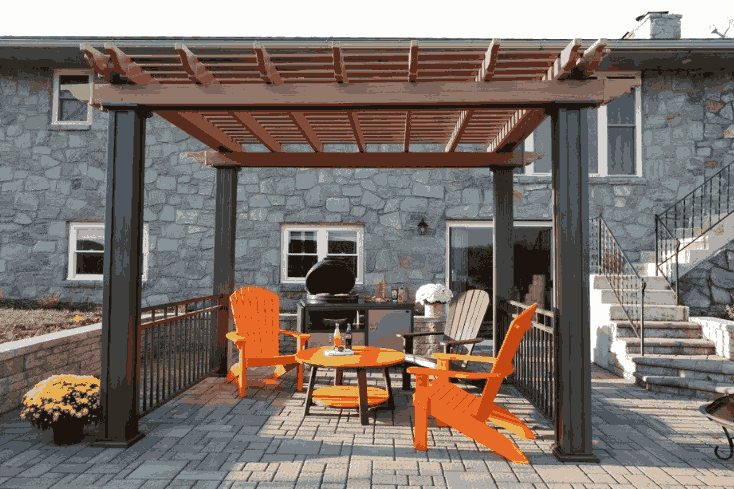 Stone house with wooden pergola and chair and table outside of the house 