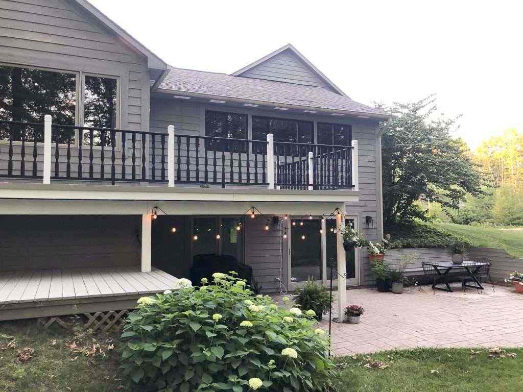 Black balcony and white trim and some lights on the wall and glass window