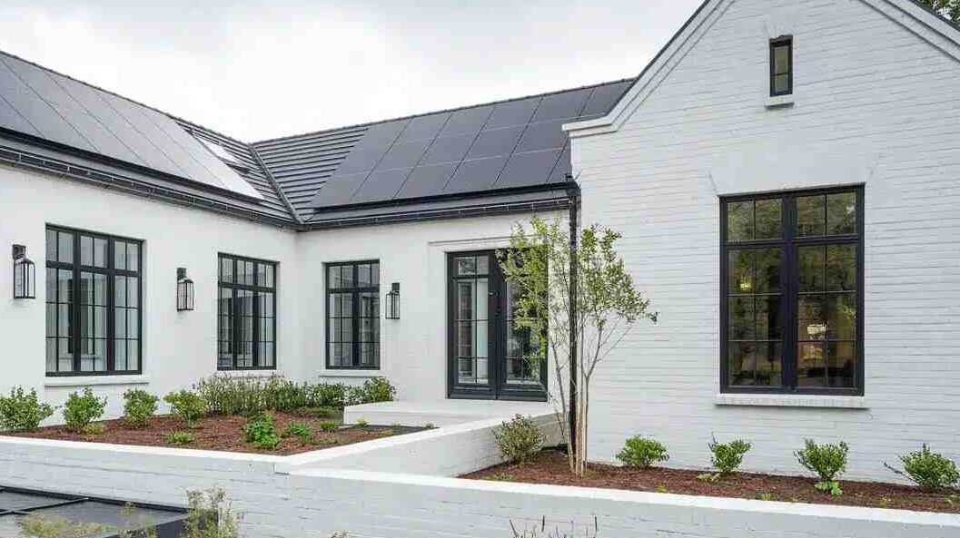 A white house with black cashing windows and black scones 