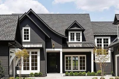 Dark grey house with black fascia and white trim windows 