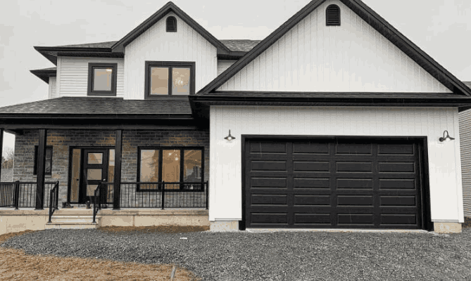 Black garage door on white house and black framed windows and black railing