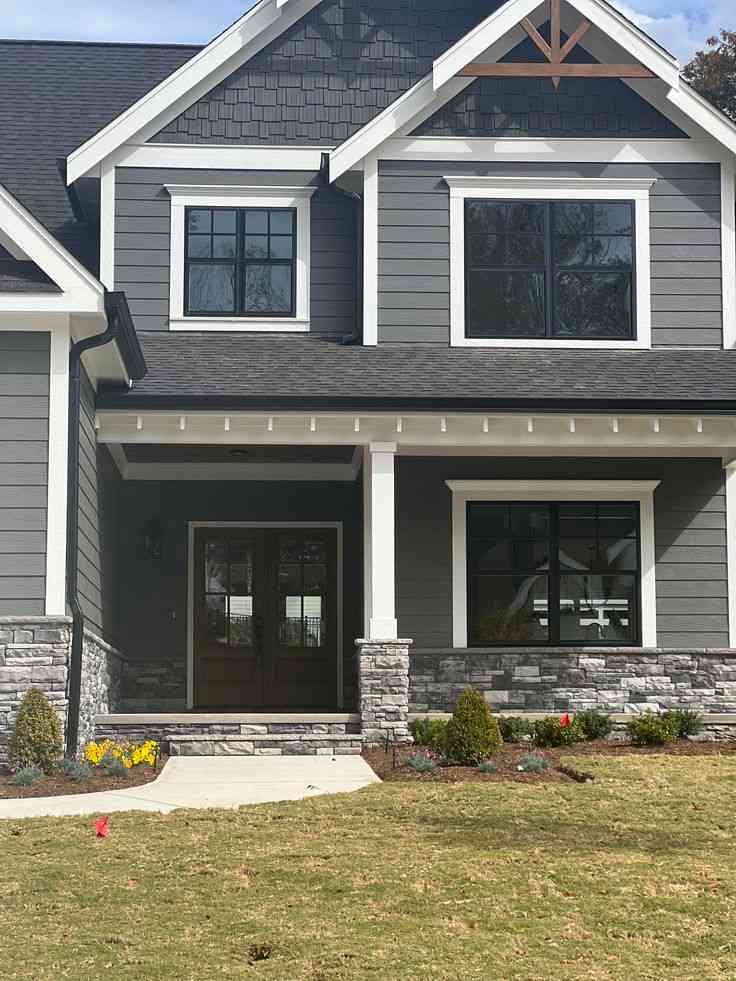 A grey house with white trim and black gutter
