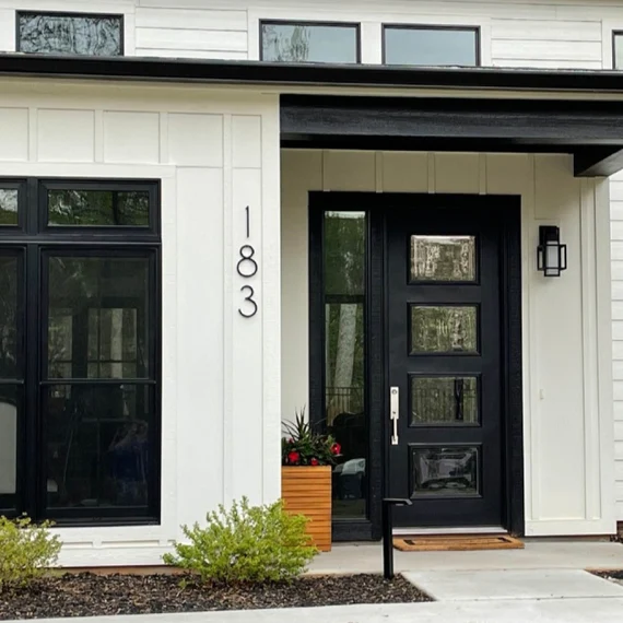 White house with black number on wall and black glass door