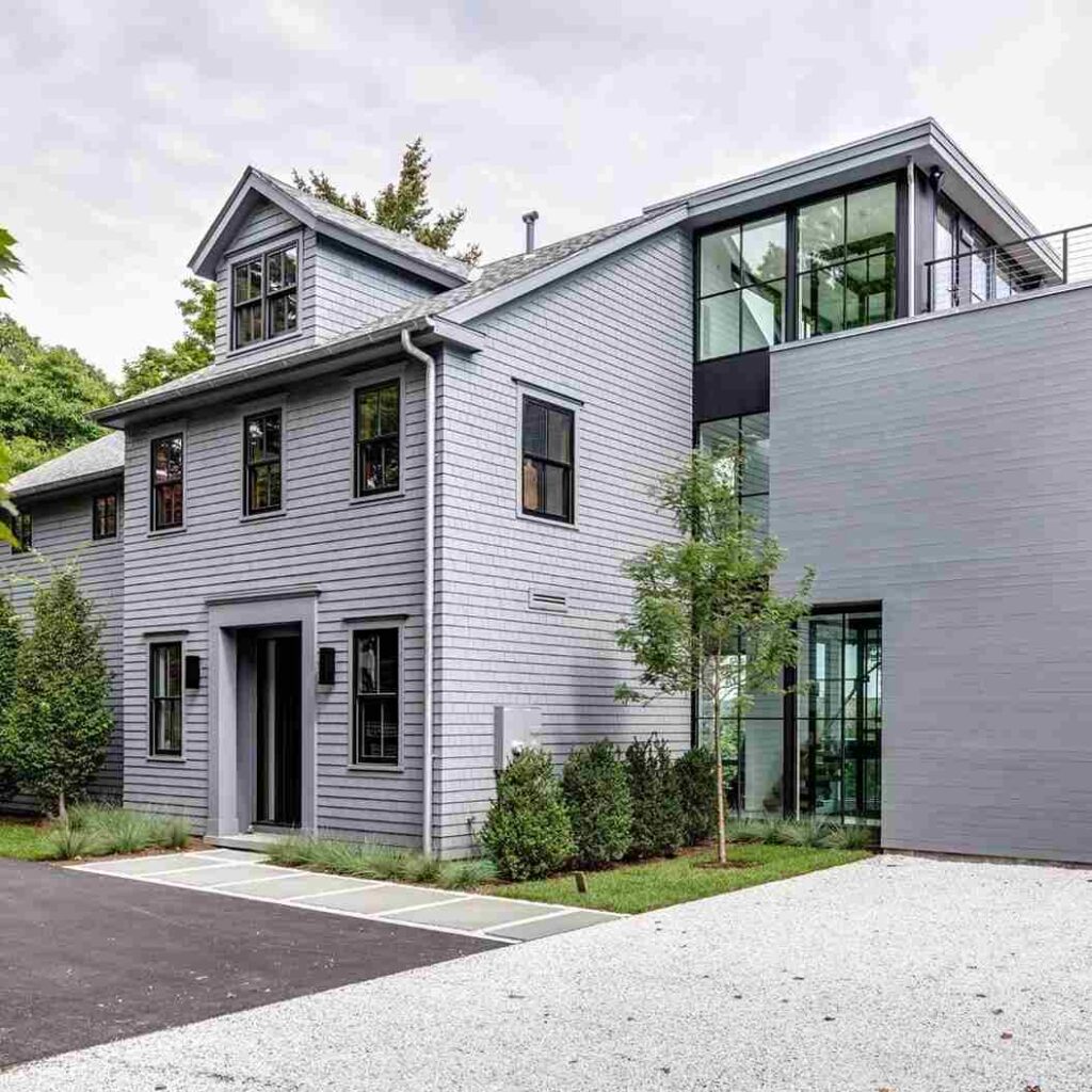 Grey house with black windows and lights on the wall