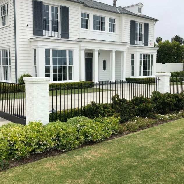 White house and around the black fencing and garden outside of the house