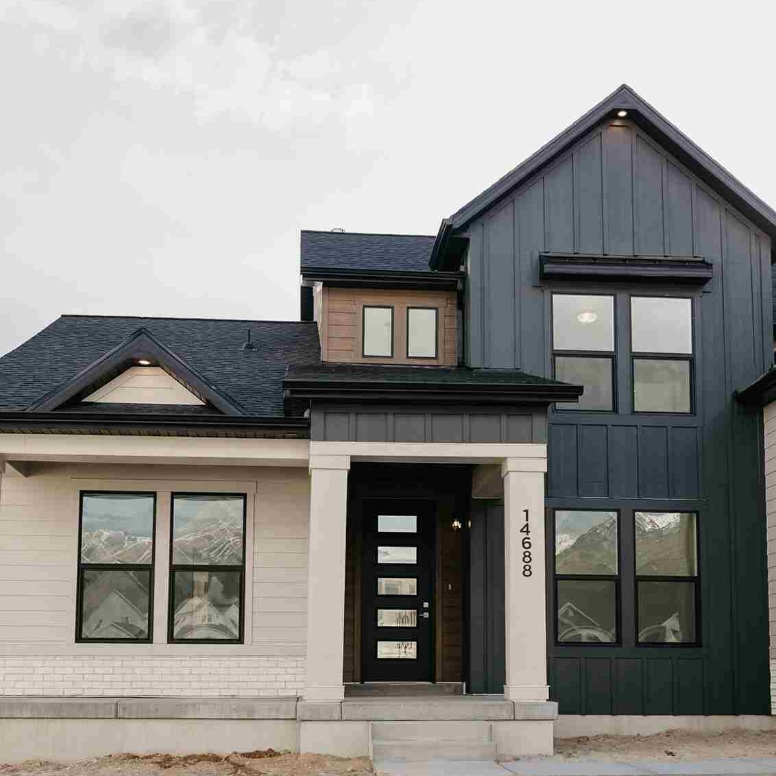 black sidling on tan house and black framed window