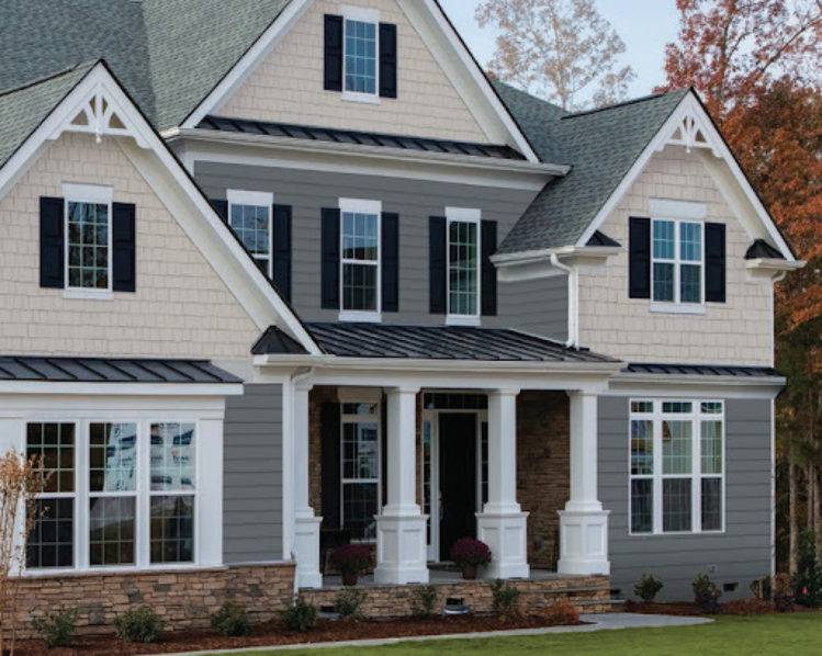 Three shades of gray and black trim and white pillars and stone and glass window