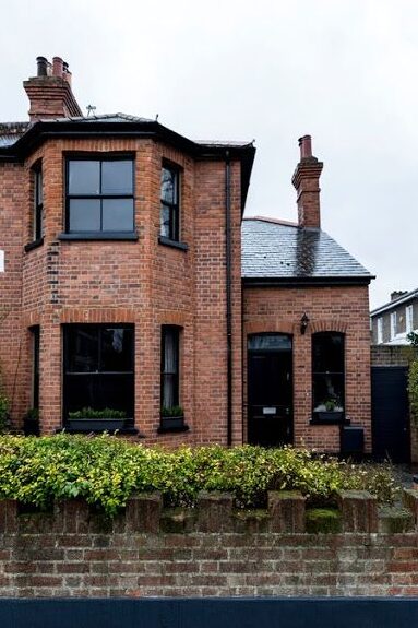 Black windows and black roof on red brick house