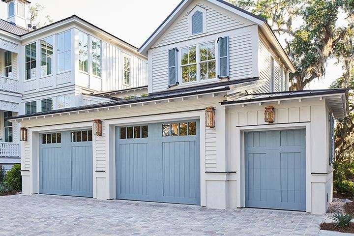 White house with blue garage and lights on the wall