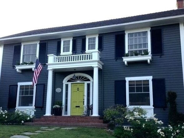 Blue house with white trim and black shutter and yellow door