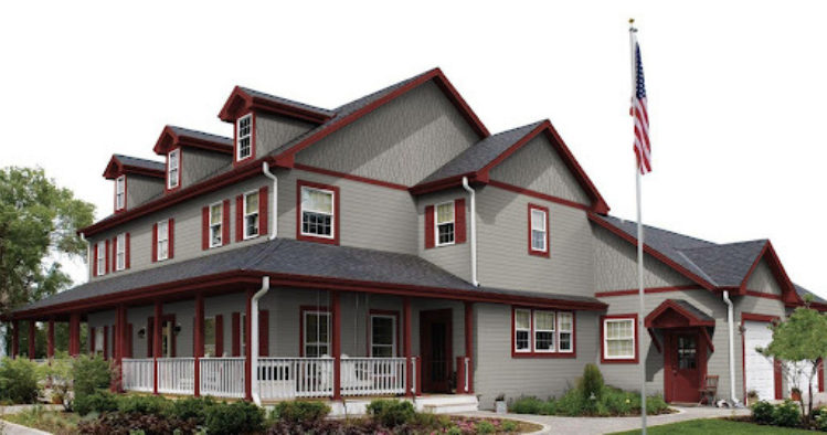 Grey house with red trim and white balcony and white trim windows