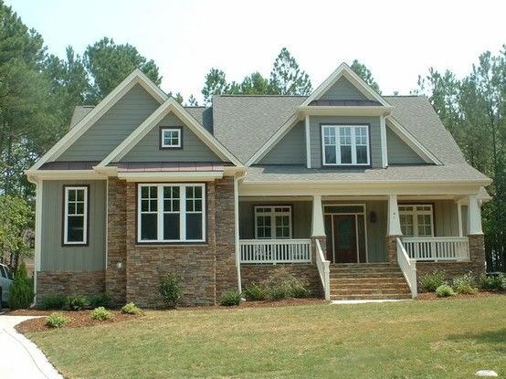 Green house and brown brick and white trim with windows