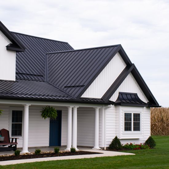 Black steep roof on white house and black trim windows and white pillars