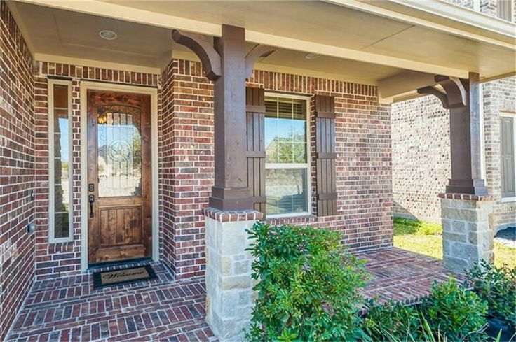Charcoal pillars on red brick house and white framed windows