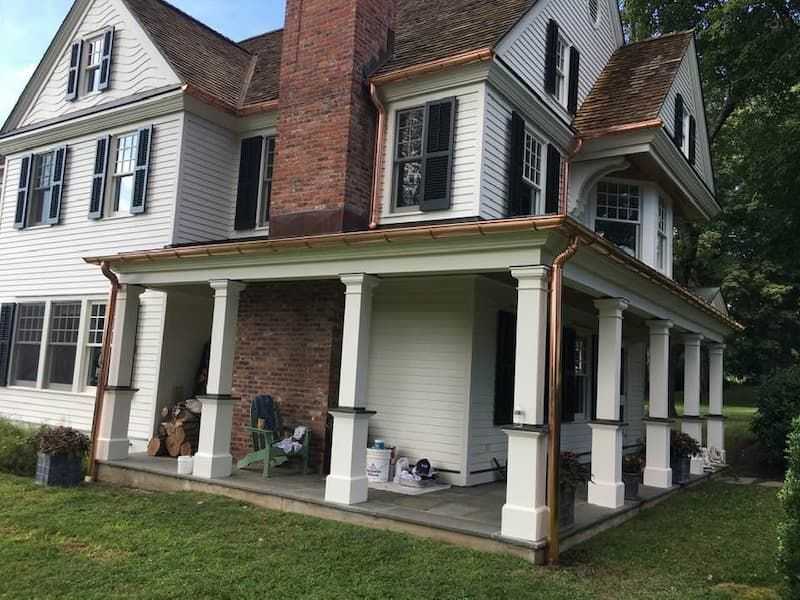 Copper gutters on white house with black windows