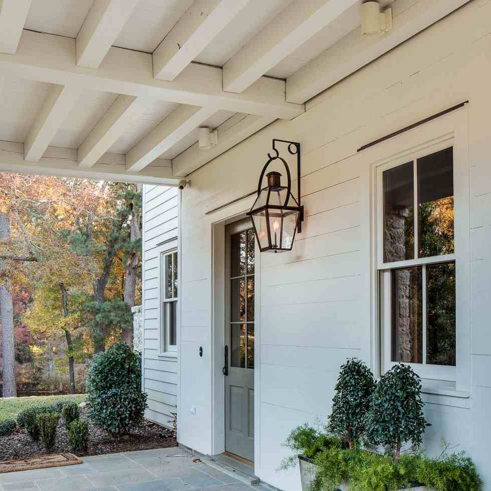 White house with copper lights on the wall and white windows