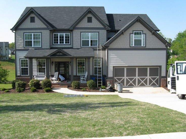 Light and dark grey house with white trim windows and garden outside of the house