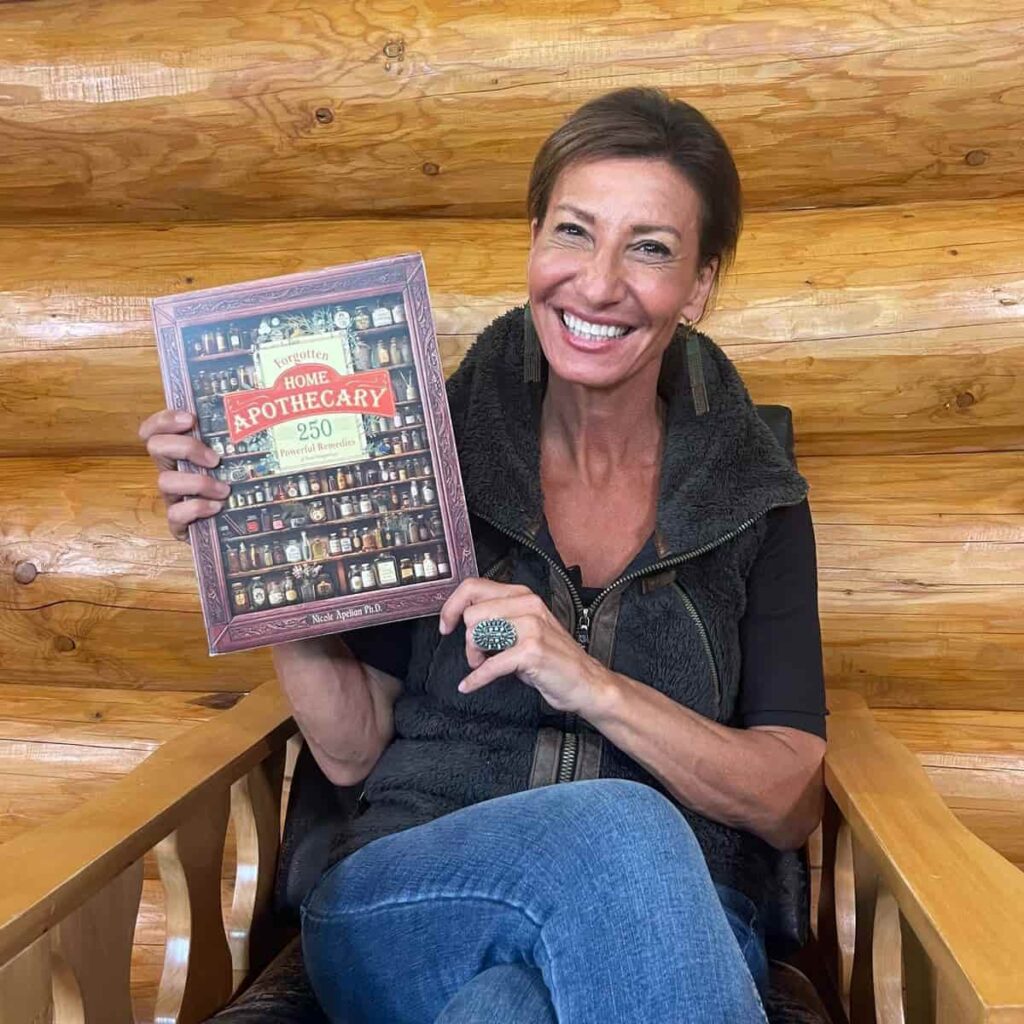 Dr. Nicole Apelian holding her book, Forgotten Home Apothecary
