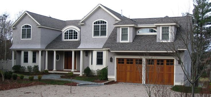 Garage wooden door on grey house and white pillar and windows