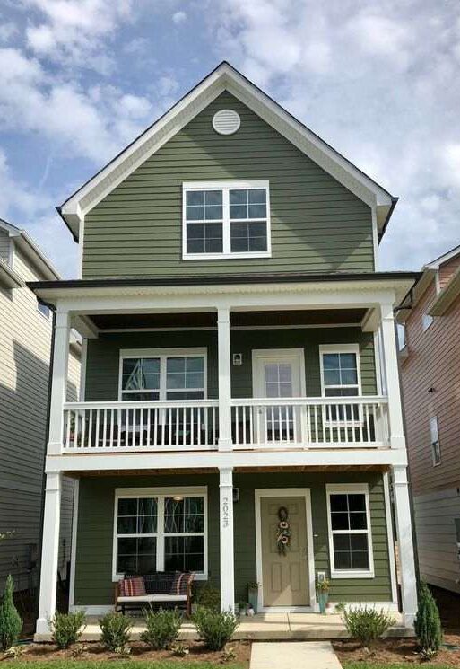 green house with white balcony and white trim windows