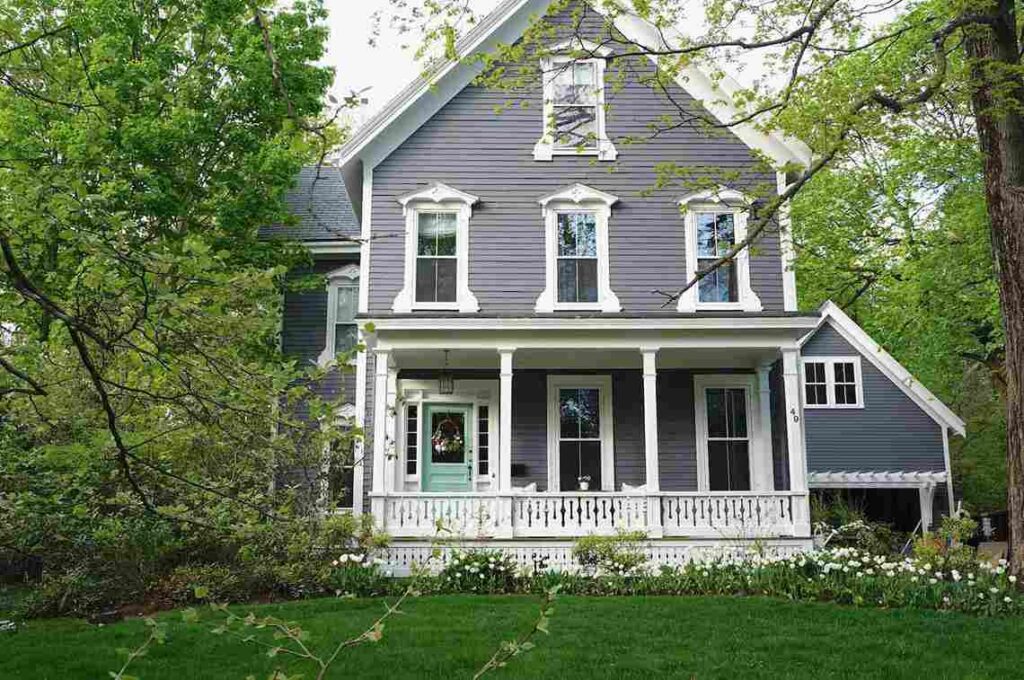 greenery around grey house and white windows