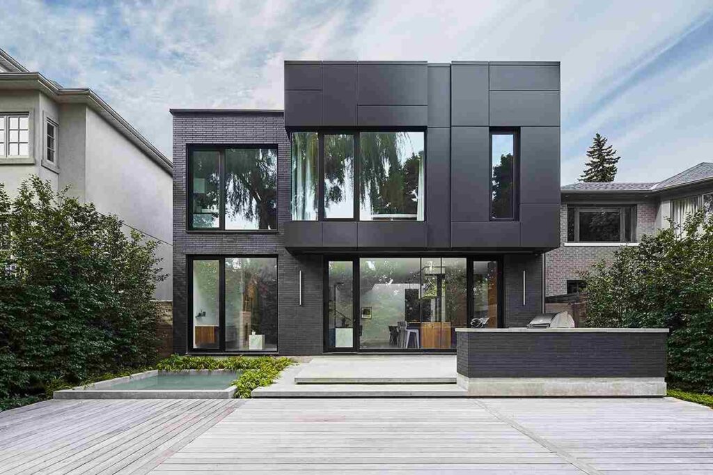 Black house with grey and glass windows and a pathway outside of the house