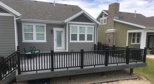 Grey house with lack balcony with white trim windows