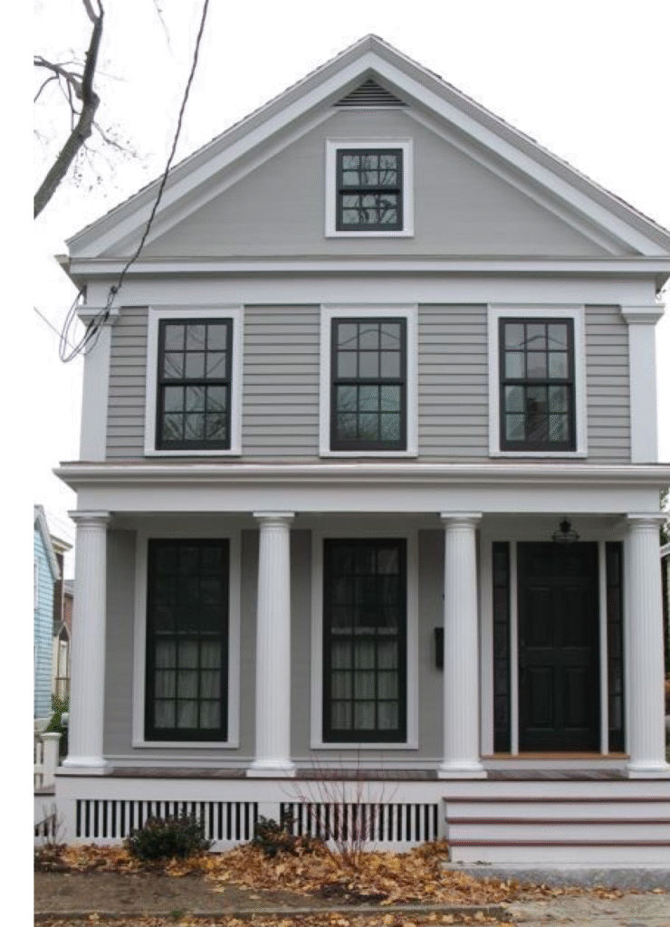 A grey house with black trim windows and and white pillars