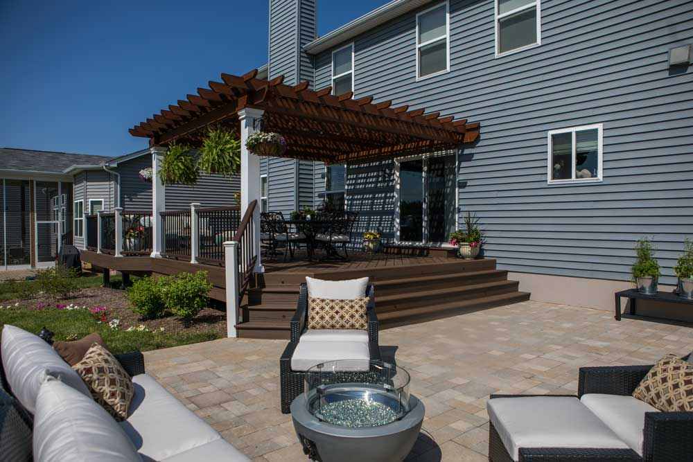 Grey house with wooden pergola and white windows