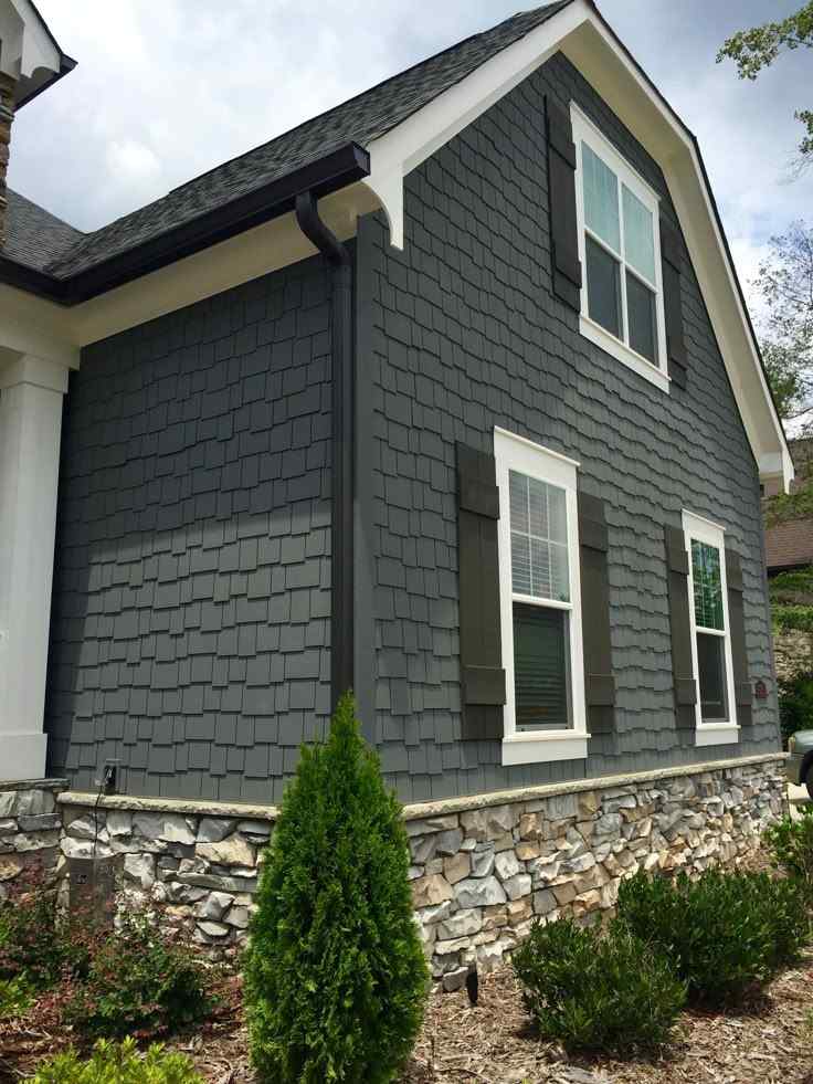 Grey brick house and black gutter and white trim windows