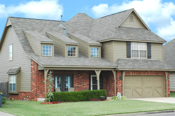 Grey sidling on red brick house and garden outside of the house