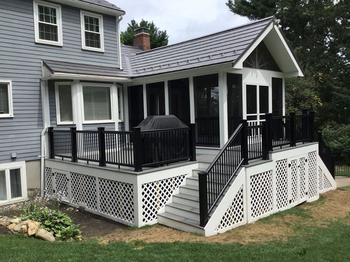 Grey house with white framed window and stair with black railing