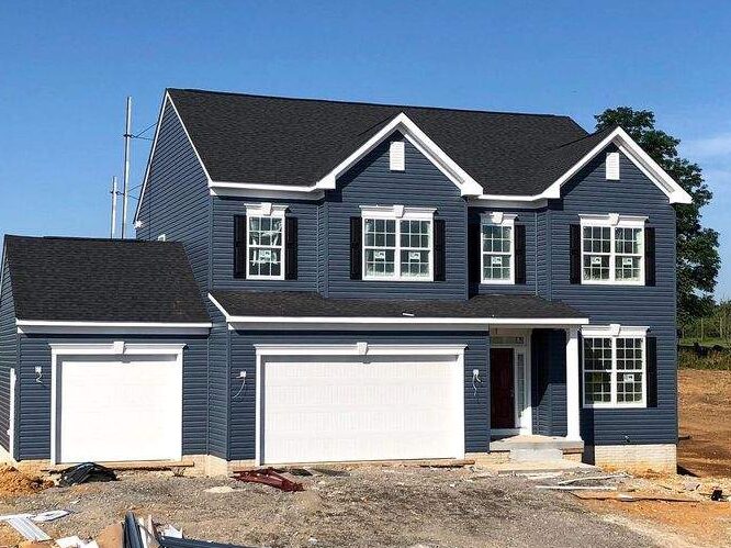 Blue house with black roof and white trim windows