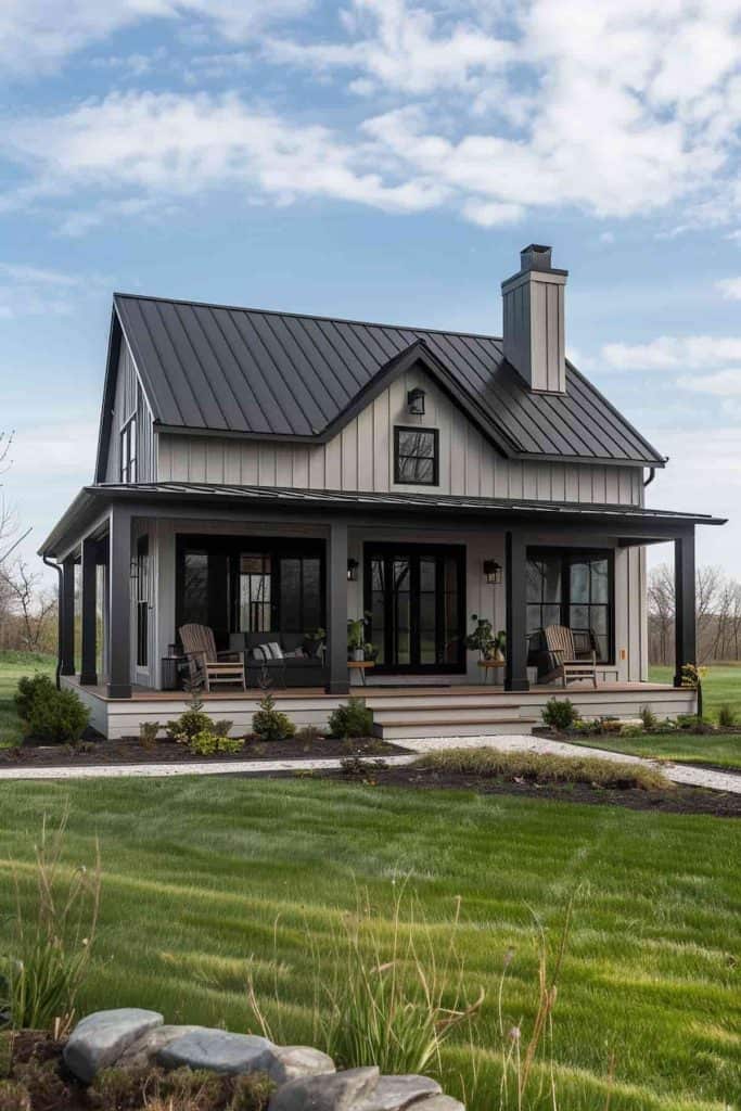 A light gary house and black roof and chair outside of the house 