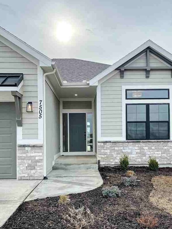 Grey house and black number on the wall and black glass windows