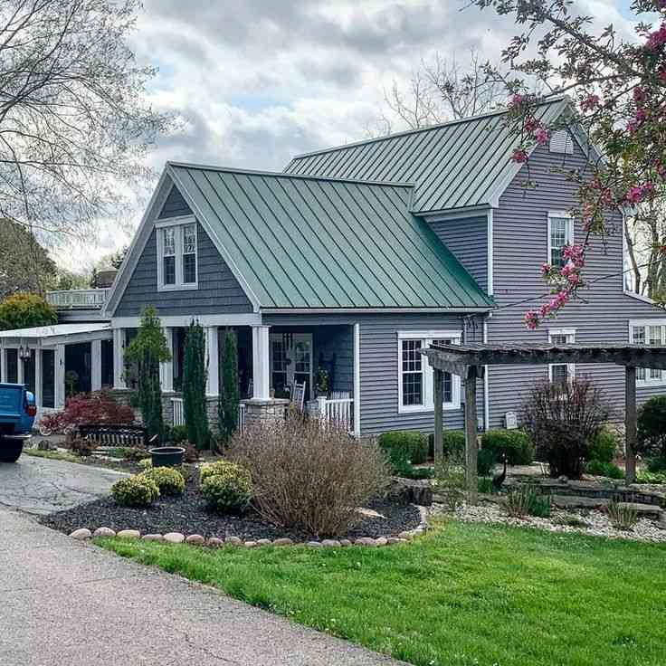 Light grey house with green roof and white framed windows