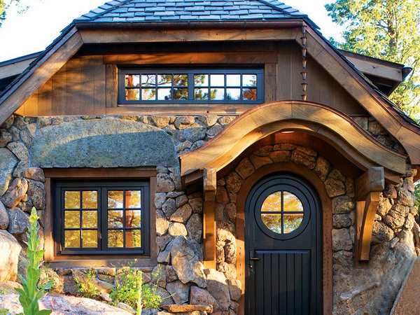 Stone and wood house with black front house and black framed windows