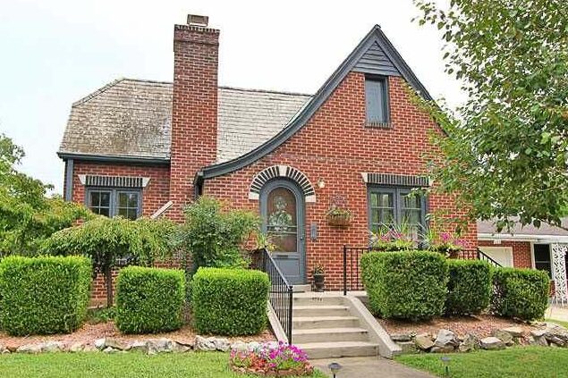 Red brick and charcoal trim with black windows and stair with black railing